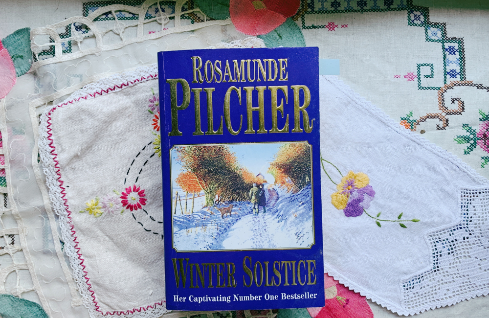 Rosamunde Pilcher's Winter Solstice sitting on a background of vintage doilies