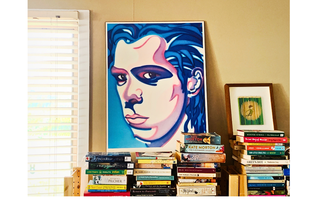 Pip's bookshelves loaded with books and a Nick Cave poster and Ghostpatrol piece are propped on top of the piles of books