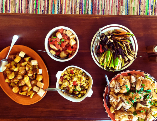 Tabletop with five platters of buffet-style food